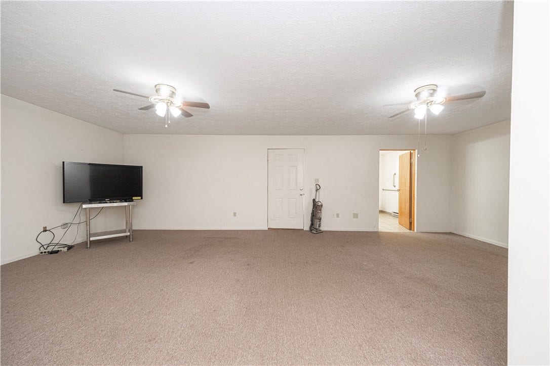 There is a large multi-purpose room adjacent to the porch that was used as living space for a disabled family member.  It is big enough to contain a bed, sofa, and dining table.  The TV will be removed.