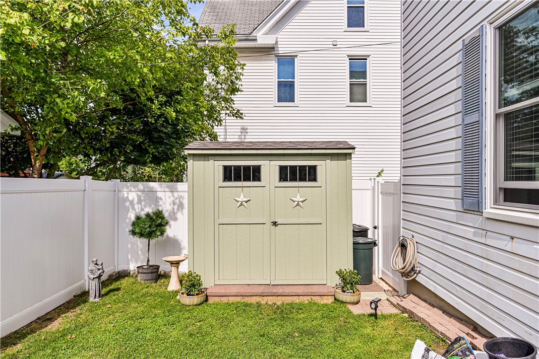 THE SHED IS AN ADDED TOUCH TO THE SIDE YARD OF THE HOUSE THAT ALSO PROVIDES NEEDED STORAGE FOR YARD TOOLS ETC