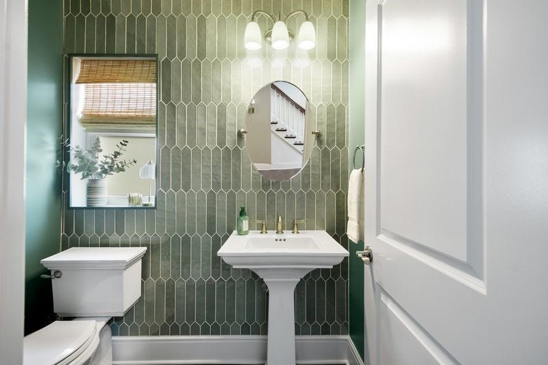 Half bath with accenting ceramic wall.