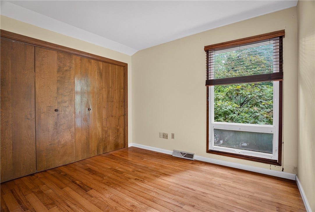 Comfortable secondary bedroom with peaceful wooded views.