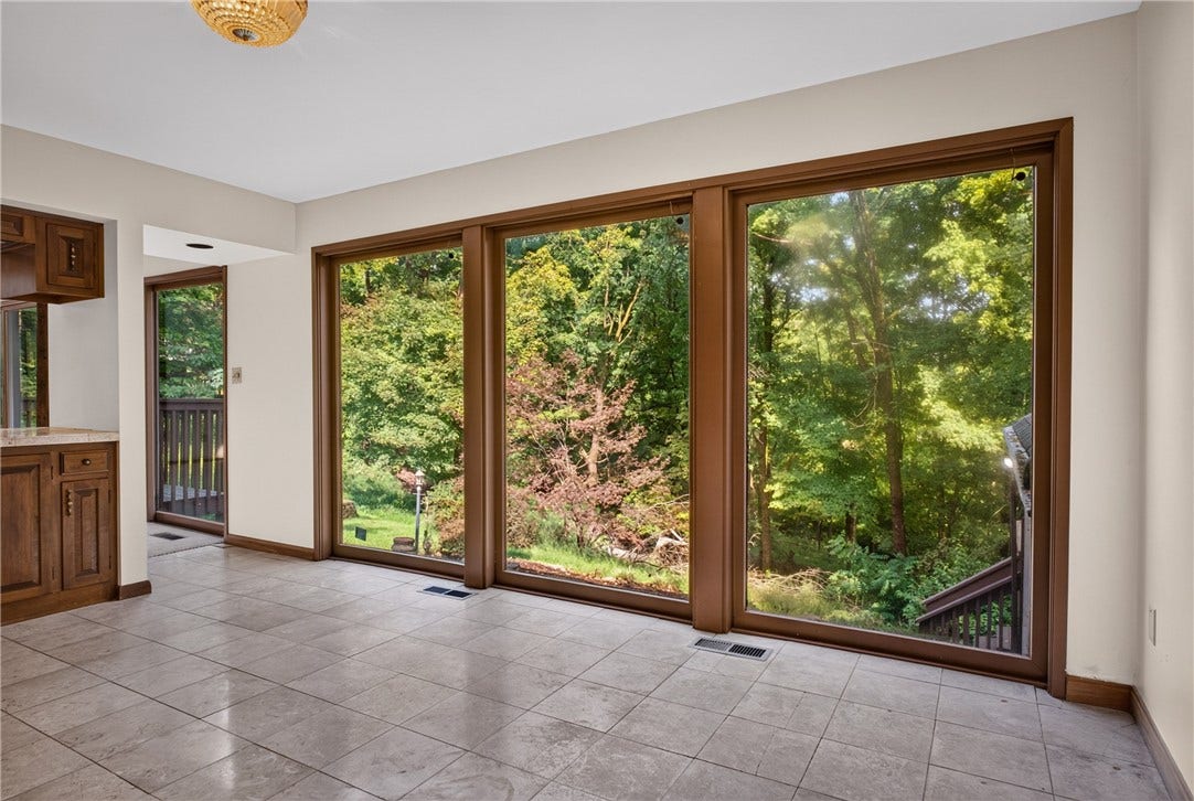 Walls of windows showcase the home's beautiful wooded setting.