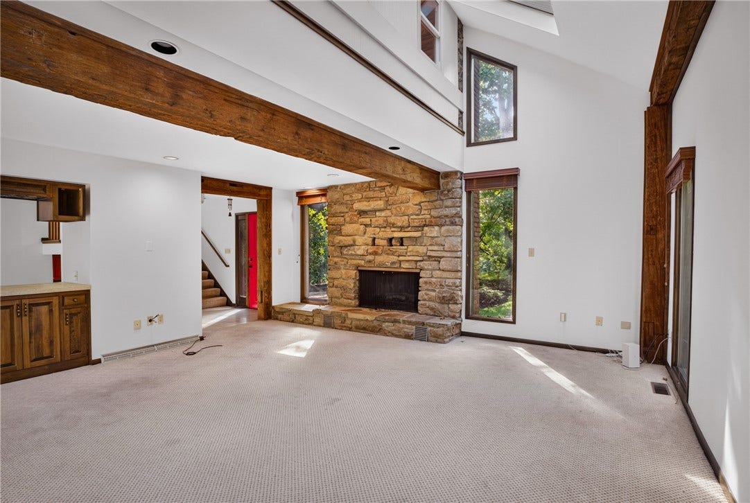 The inviting living room features a striking stone fireplace.
