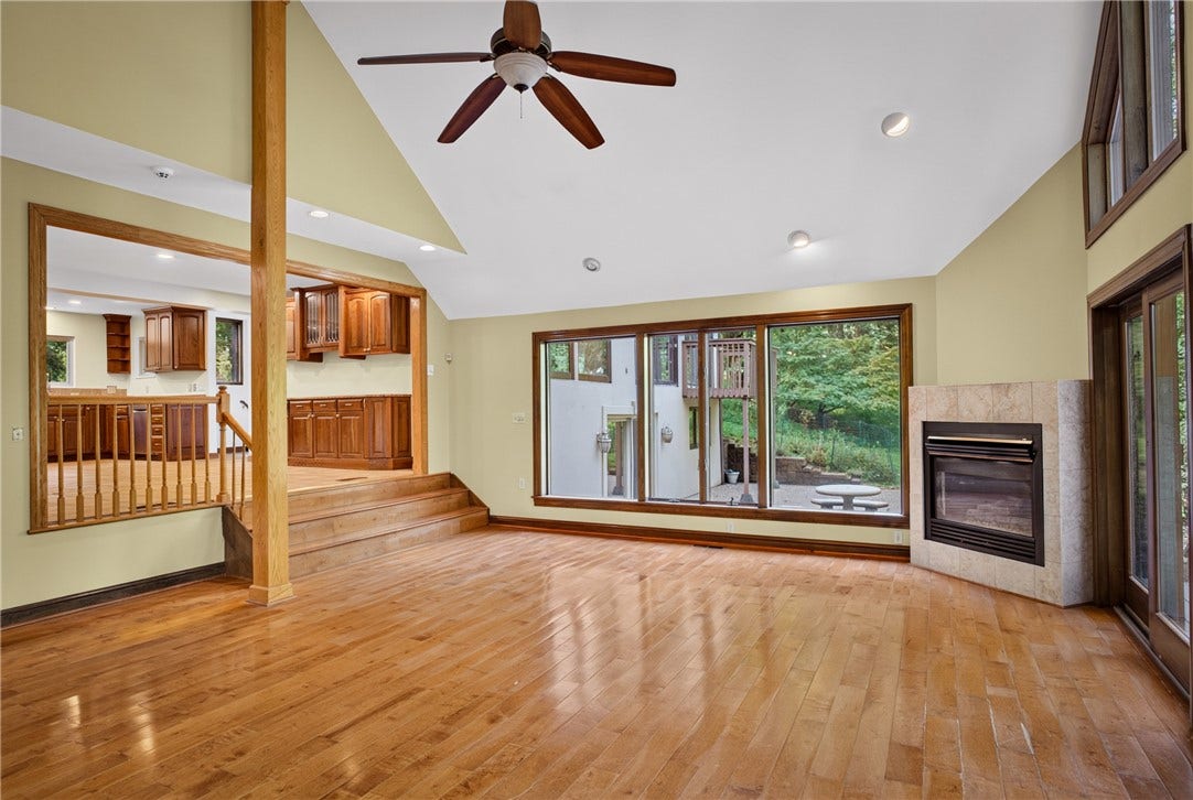 The step-down family room is surrounded by windows and natural light.