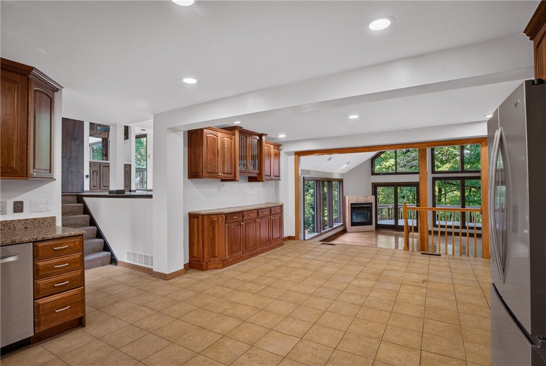 The eat-in kitchen features walnut cabinetry and granite countertops.