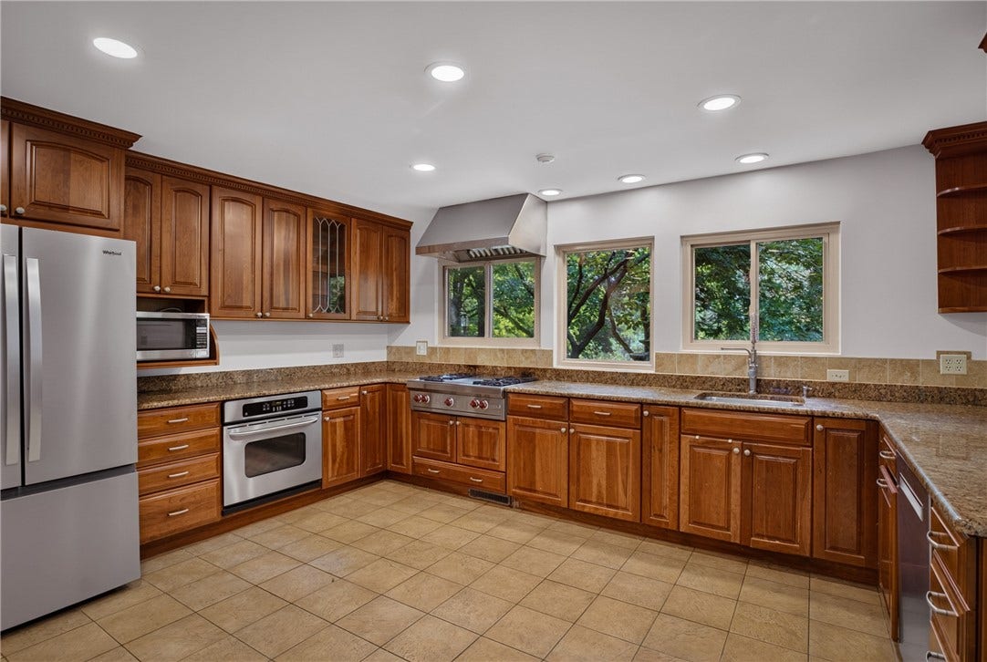 Stainless steel appliances complement the warm walnut cabinetry.