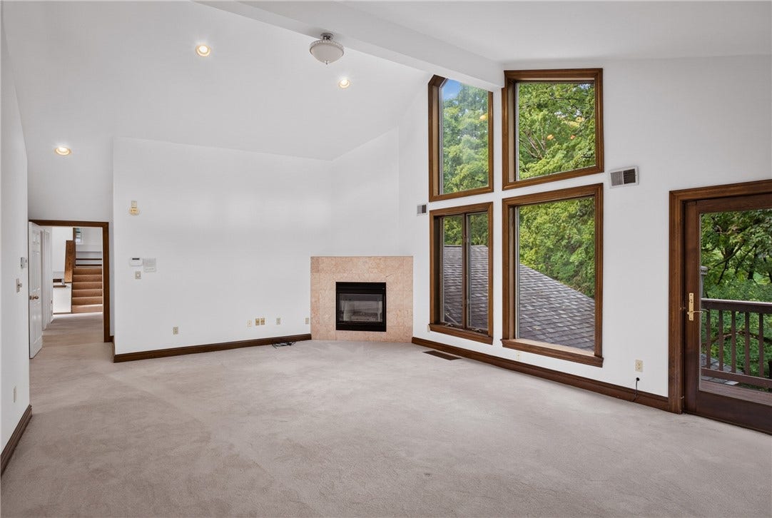 A vaulted ceiling and fireplace add warmth to the primary bedroom.