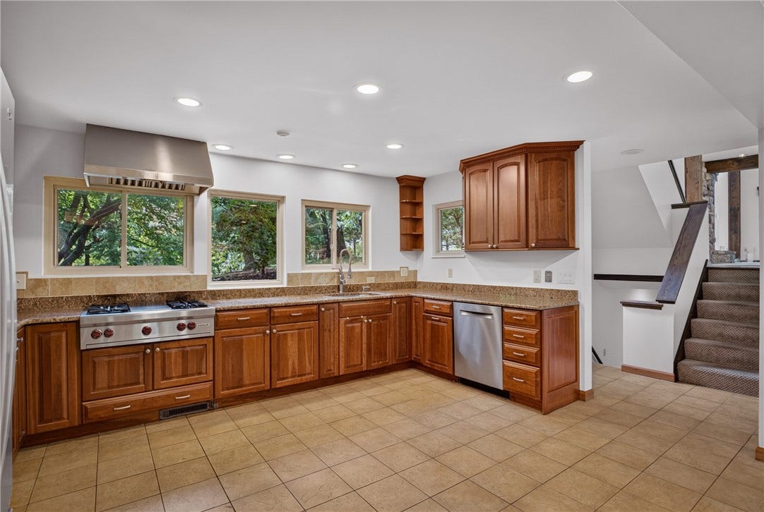 A Wolf gas range with grill anchors the well-appointed kitchen.