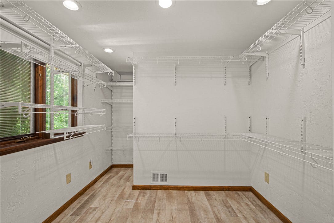 An oversized walk-in closet with built-in storage keeps the primary suite beautifully organized.