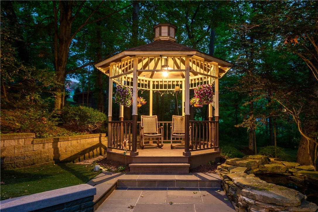 A charming illuminated gazebo creates an intimate destination for conversation, cocktails, or quiet evenings surrounded by nature.