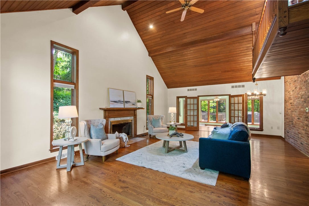 Soaring wood ceilings, hardwood floors, and abundant natural light make this dramatic gathering space the heart of the home.