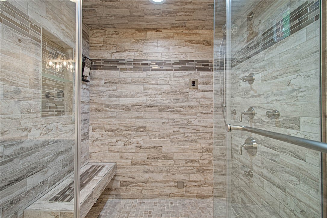 Floor-to-ceiling tile and frameless glass bring a luxurious, contemporary feel to the renovated ensuite.