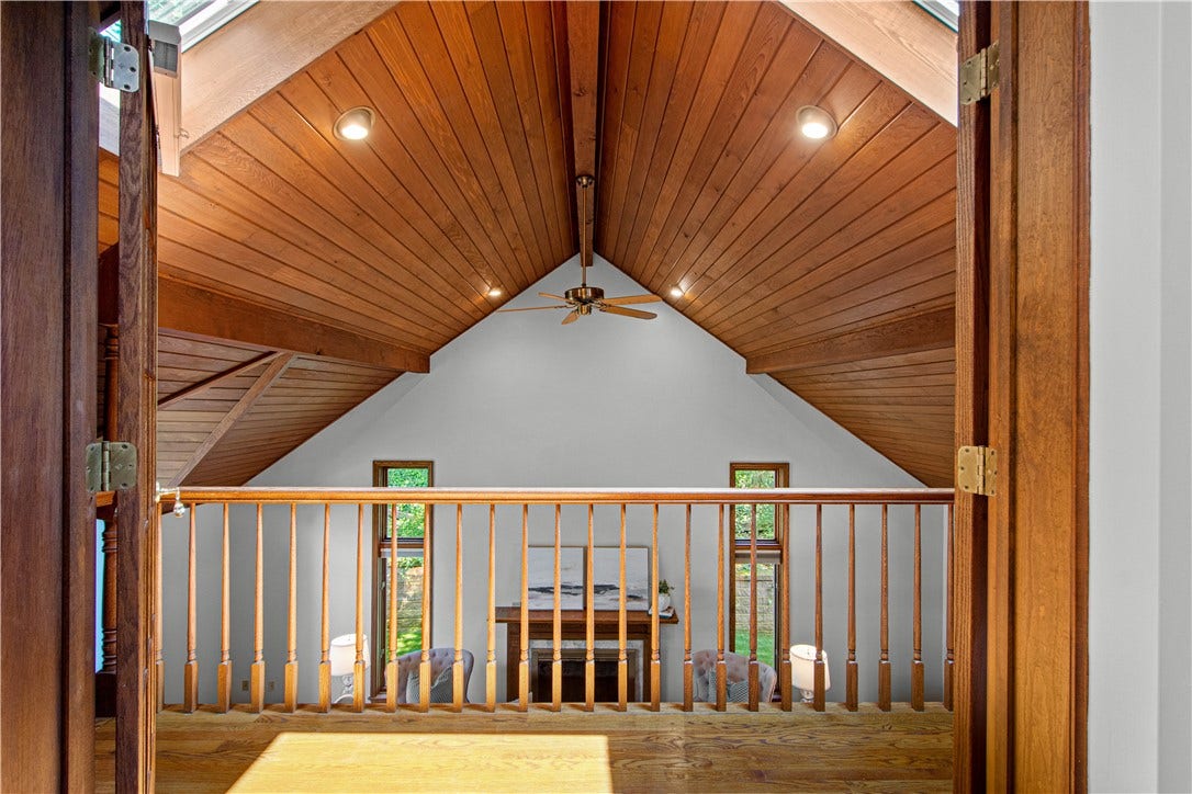A unique interior balcony connection overlooks the dramatic family room below and adds architectural interest to the suite.
