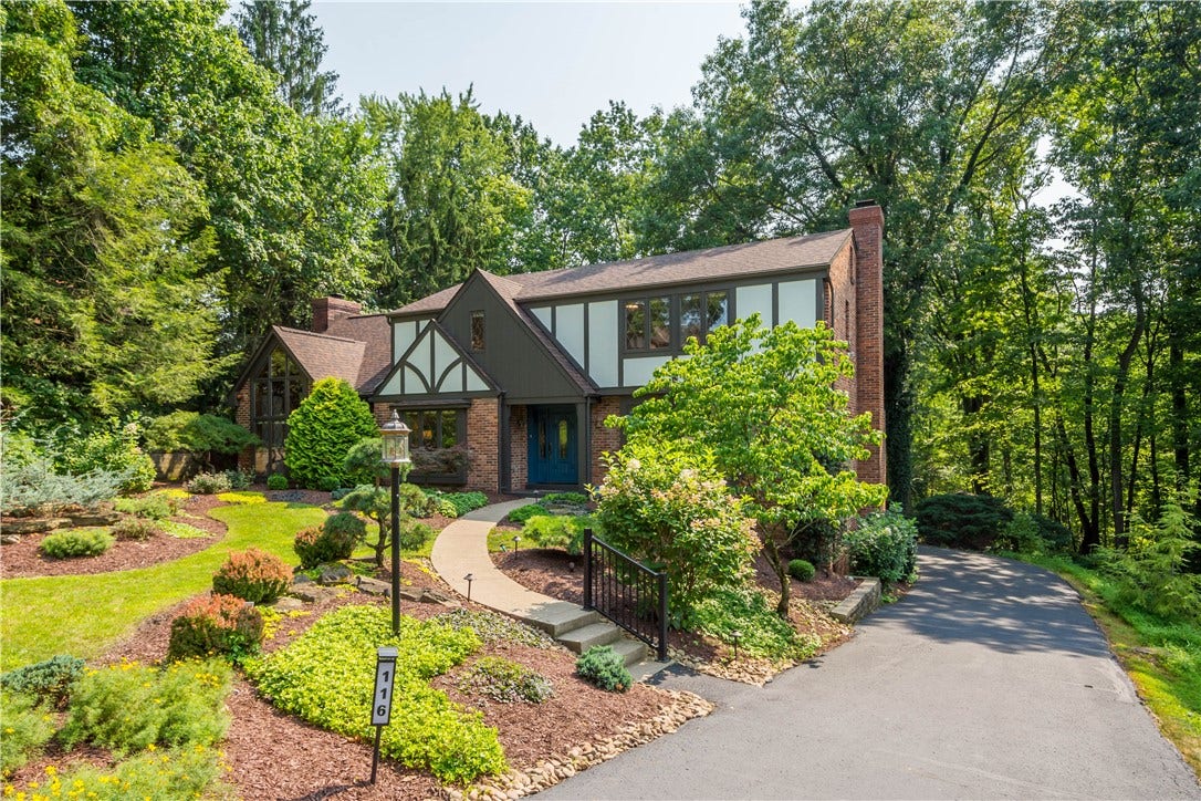 Lush professional landscaping and a winding walkway enhance the home's private setting.