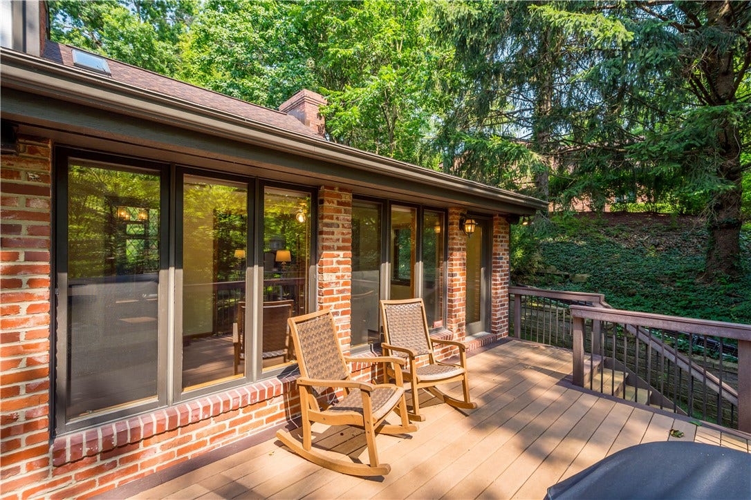 An expansive deck connects seamlessly to the home's indoor living spaces, making outdoor dining and entertaining part of everyday life.