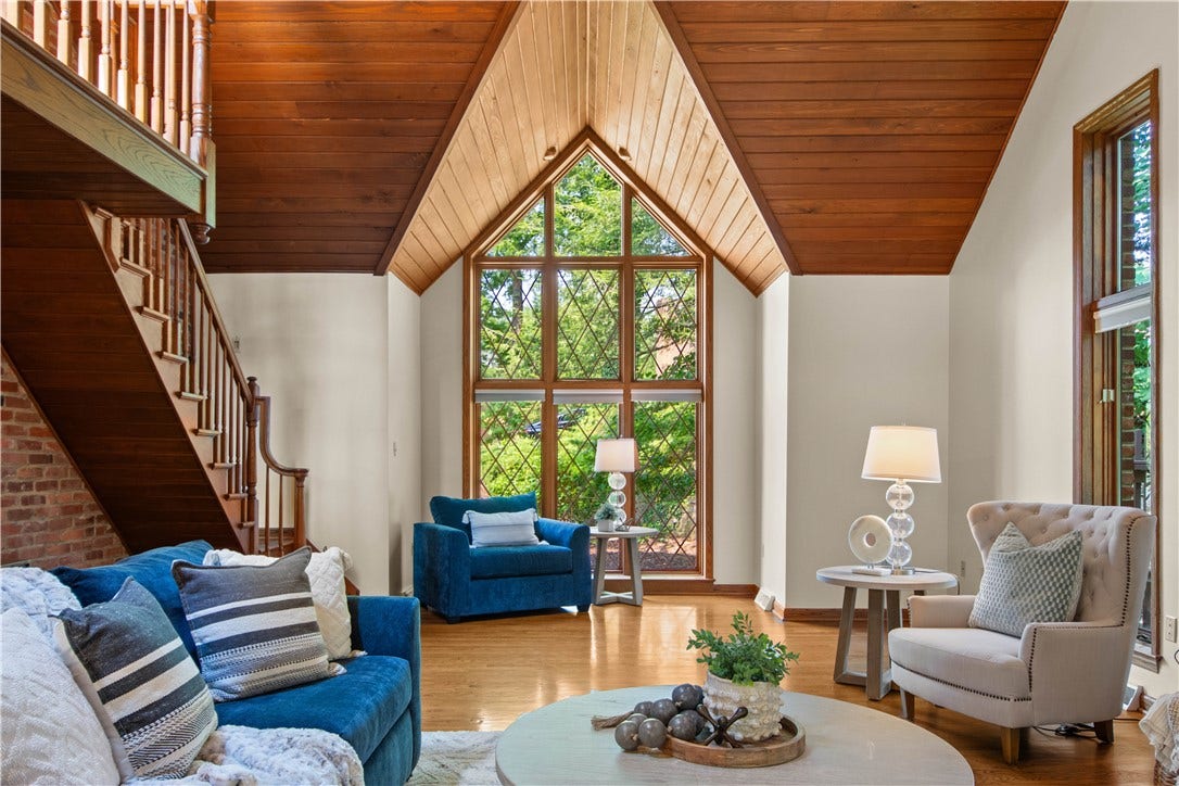 An impressive wall of windows brings the outdoors in while highlighting the room's striking cathedral architecture.