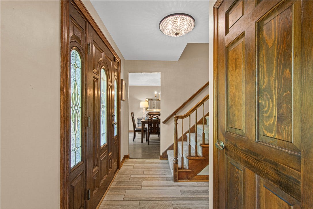 Warm woodwork and a gracious staircase create an inviting introduction to the home's timeless interior.