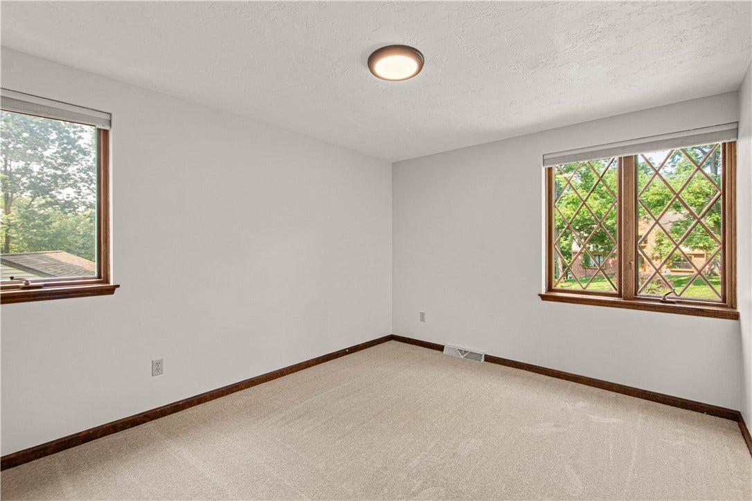 Generously sized fourth bedroom with classic Tudor-style windows.
