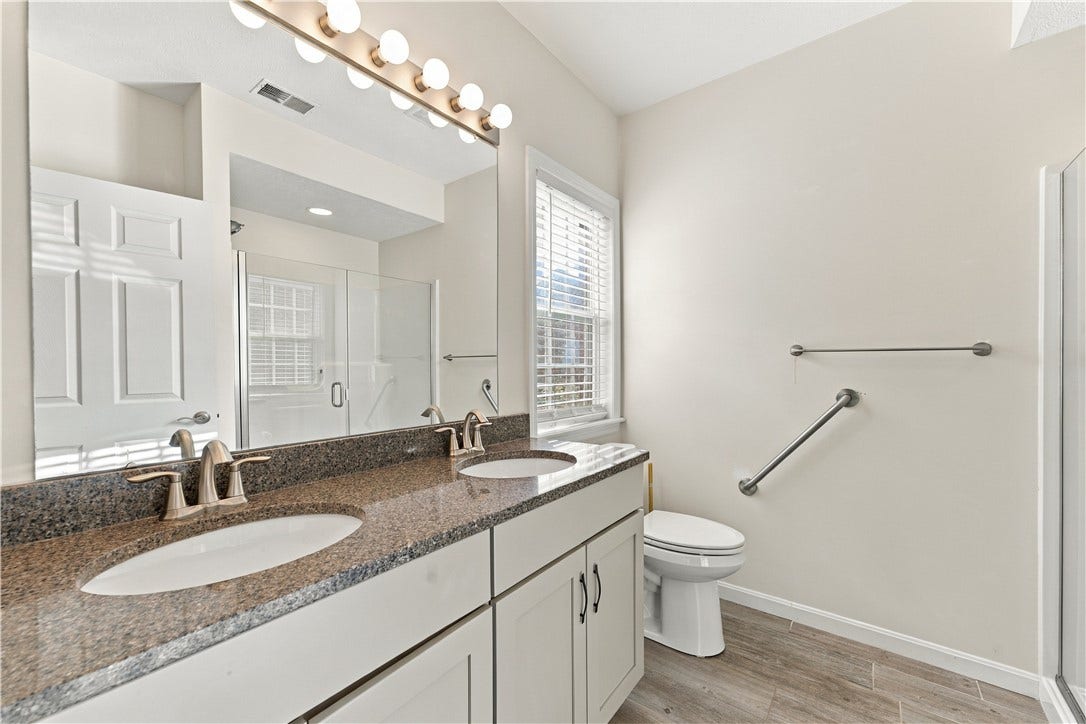 The Primary Bathroom Features a Stone Topped Double Bowl Vanity