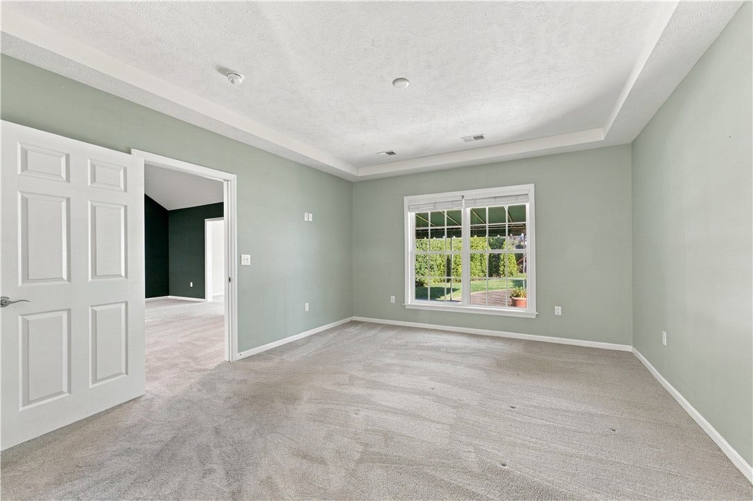 The Primary Bedroom Looks Out Onto the Lush Rear Yard
