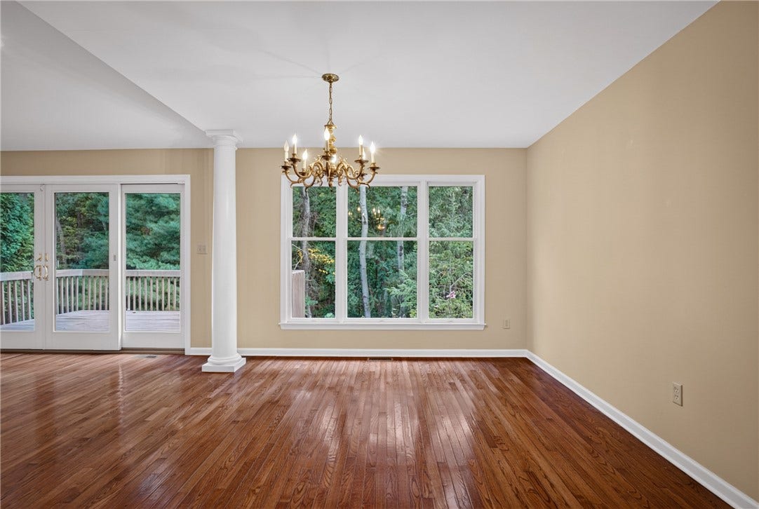 LARGE WINDOWS BRING NATURAL LIGHT AND WOODED VIEWS INTO THE DINING ROOM.