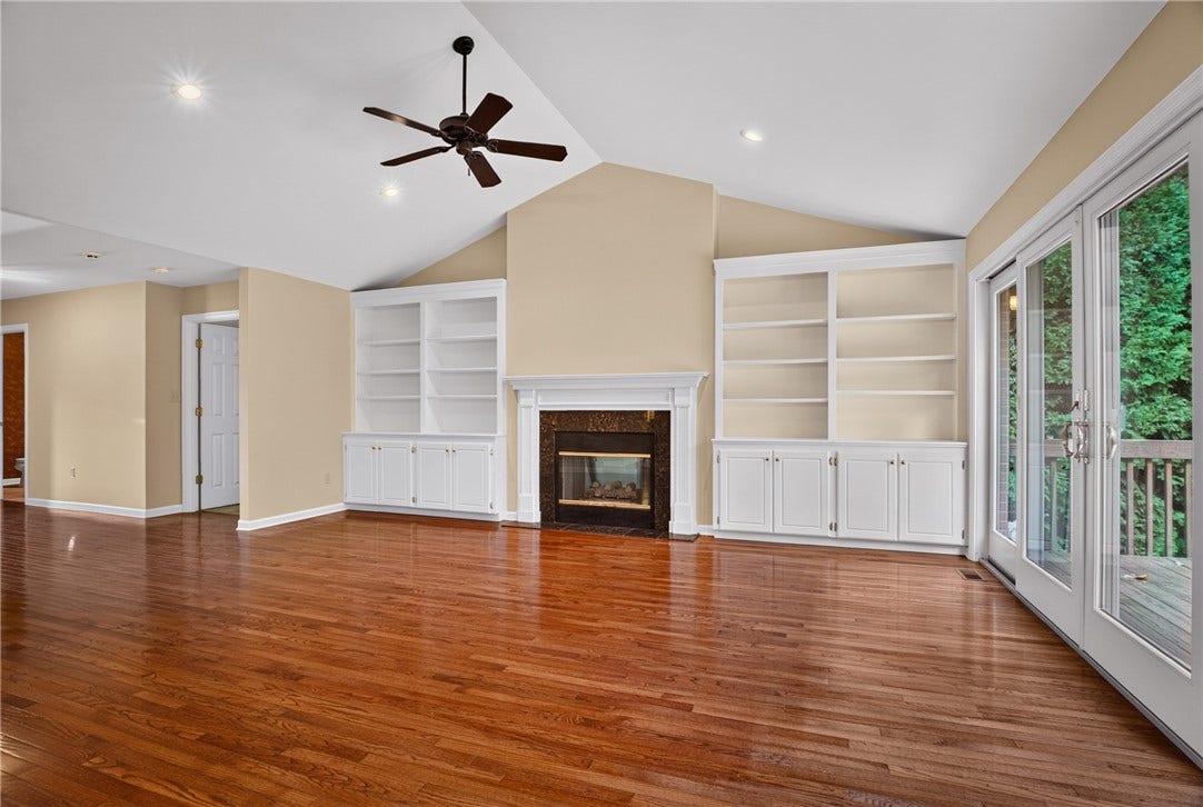 GAS FIREPLACE FRAMED BY BUILT-IN SHELVING AND CABINETRY.