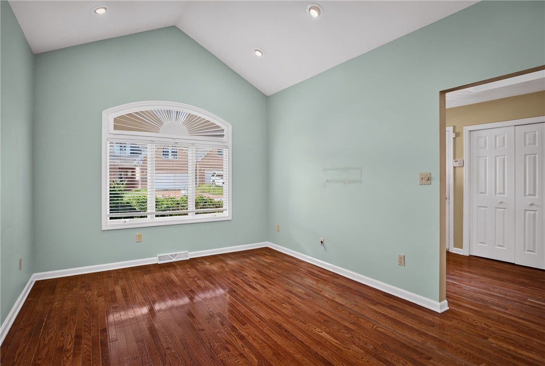BRIGHT BREAKFAST AREA FEATURING A VAULTED CEILING AND LARGE ARCHED WINDOW.