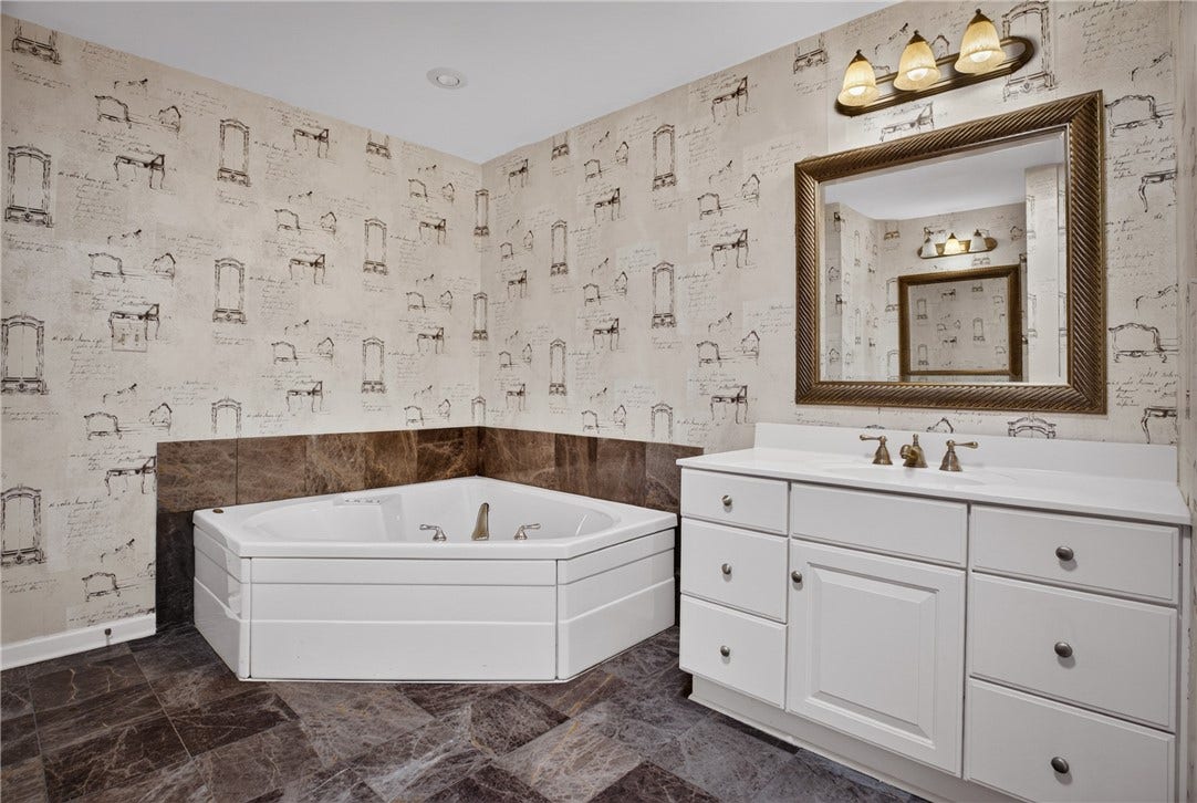 SPACIOUS PRIMARY BATHROOM FEATURING A JETTED SOAKING TUB AND SEPARATE SHOWER.