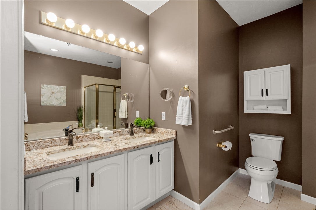 The Primary Bathroom with updated granite countertop and double sinks.