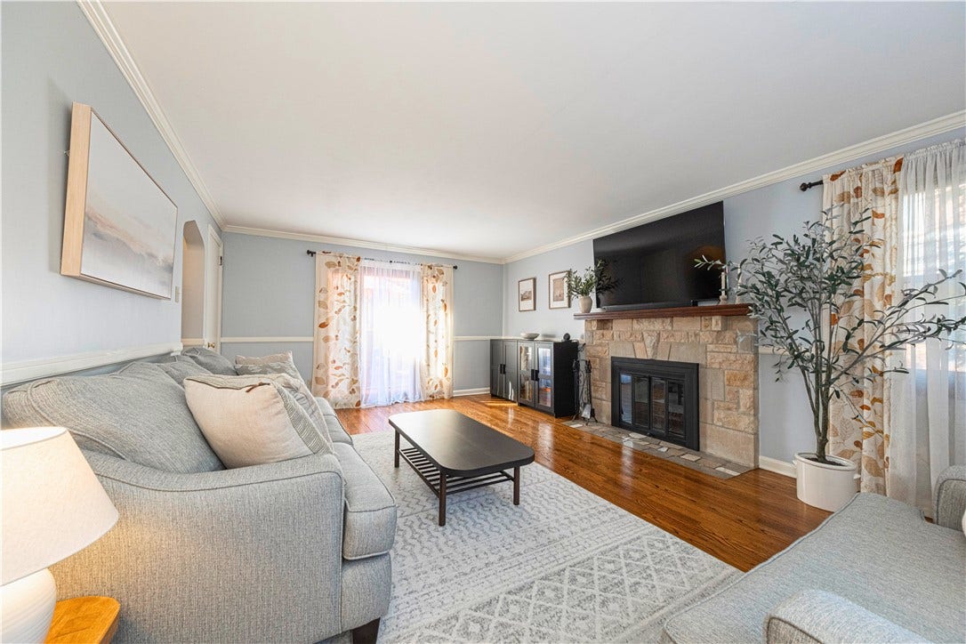 Spacious living room with hardwood floors and a wood burning fireplace.