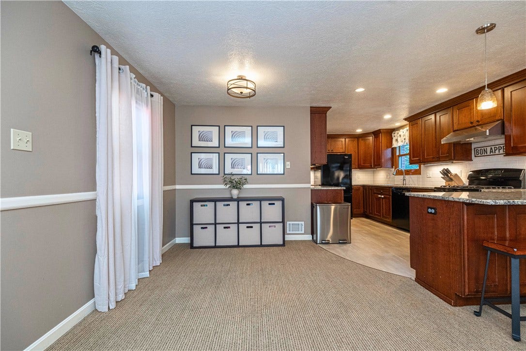 Open space off the kitchen with plenty of flexibility for a dining area, play space, or home office, plus direct access to the deck and gazebo.