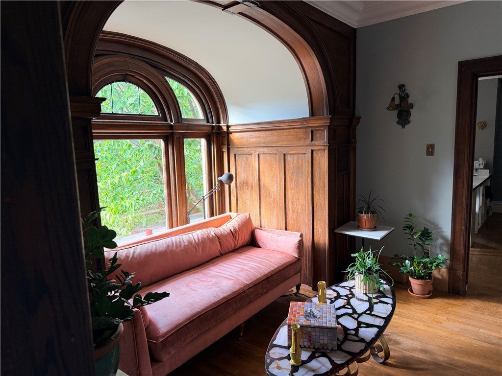 Sitting room features original woodwork and light fixtures