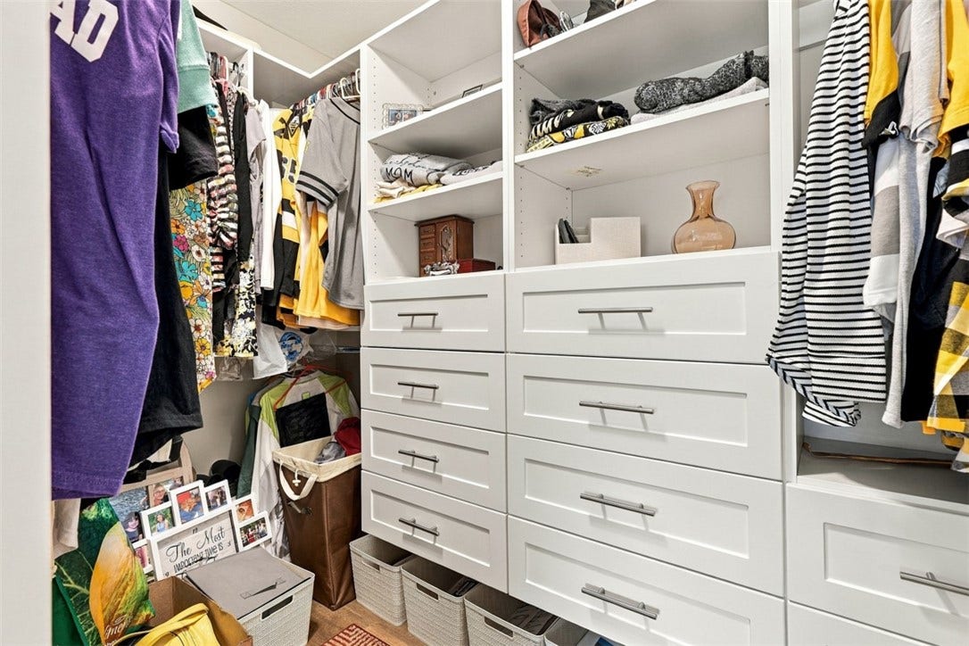 Primary bedroom spacious, walk-in closet with custom built-in drawer and storage system.