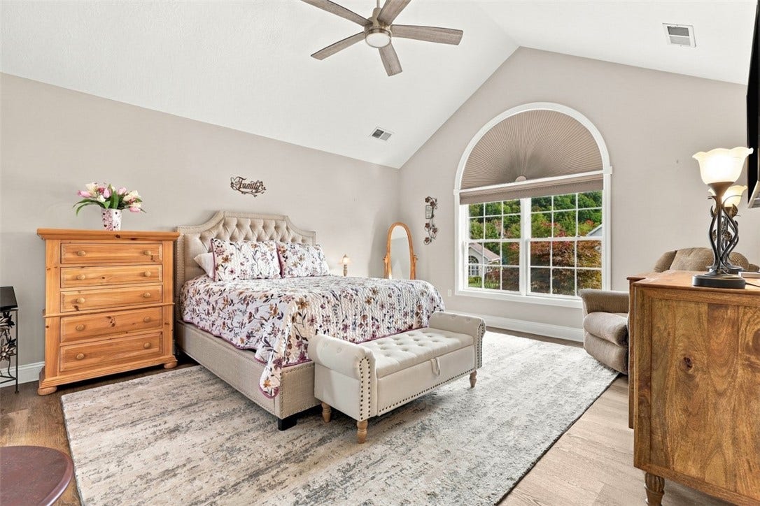 Main-level primary suite is a true retreat with a cathedral ceiling, Palladian window and generous proportions.