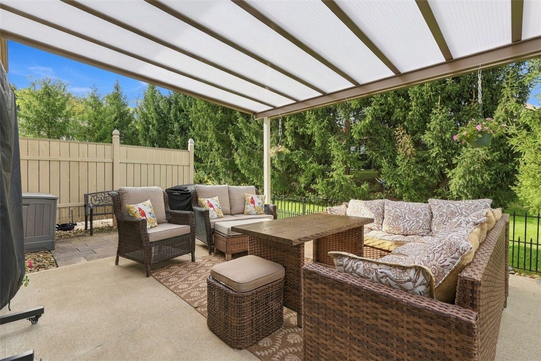 Spacious concrete patio directly off the main living area offers privacy and plenty of room to relax or entertain, with a permanent light-filtering patio cover that provides shade while still allowing natural light through.