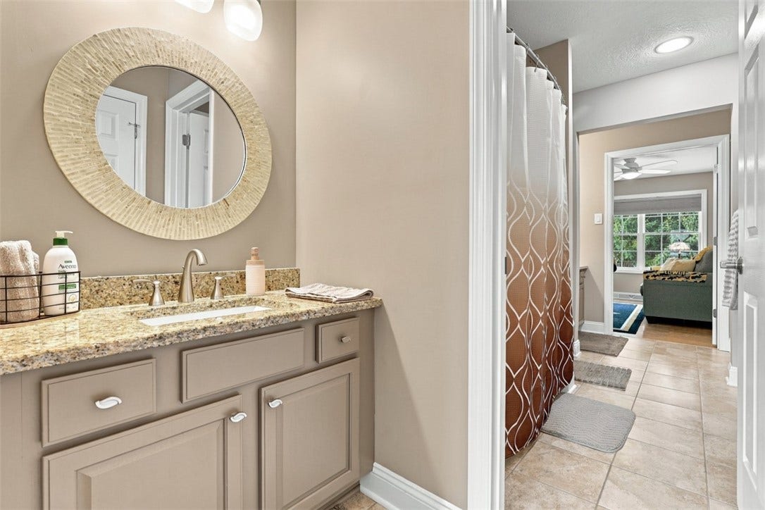 Jack-and-Jill bath shared by Bedrooms #2 and #3 features separate vanities, granite countertops, updated fixtures and a tub/shower combination.