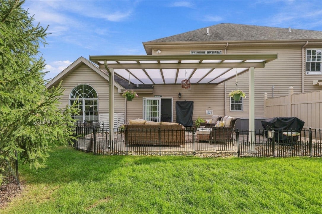 Thoughtfully designed outdoor space combines a spacious patio with surrounding green space for a seamless indoor-outdoor lifestyle.