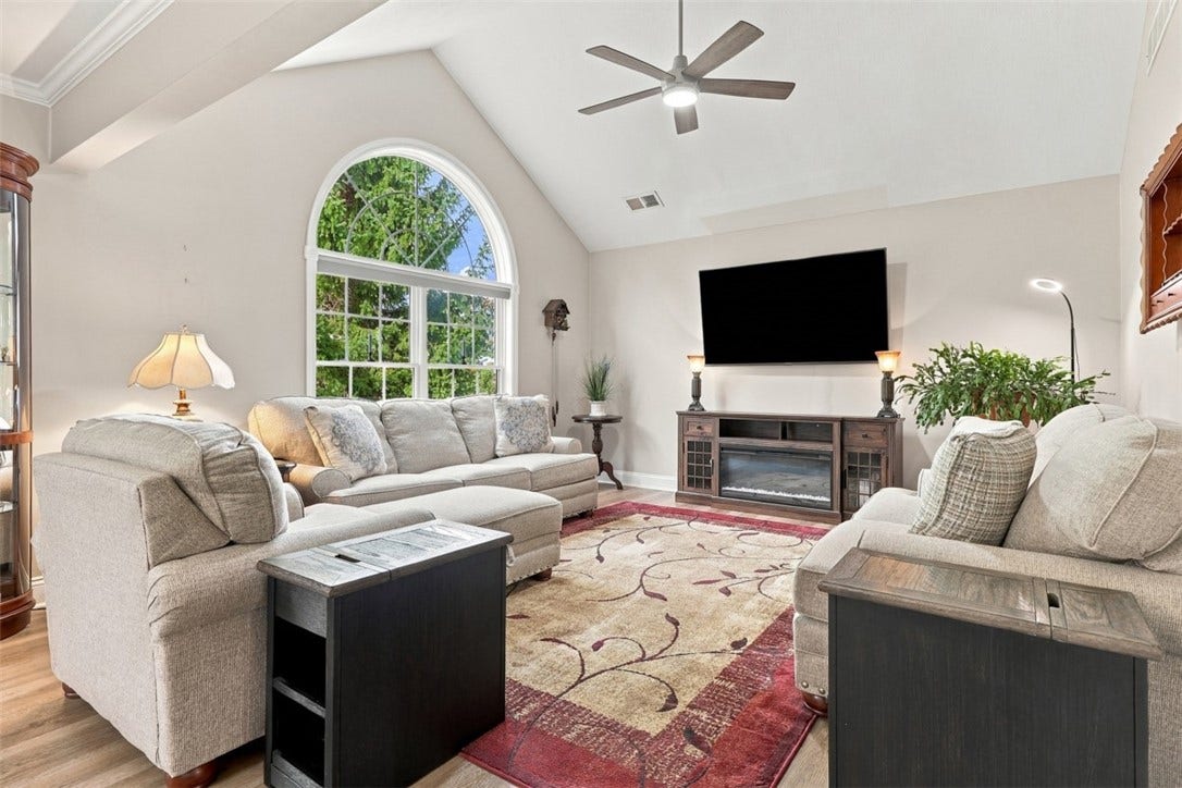 Inviting living room with cathedral ceilings and a dramatic wall of windows filling the space with natural light.