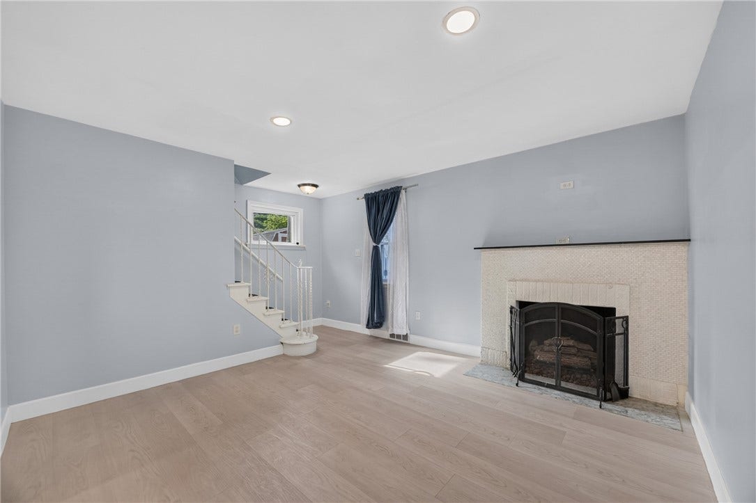 Living Room (12x12), with stairs to 2nd floor & decorative fireplace