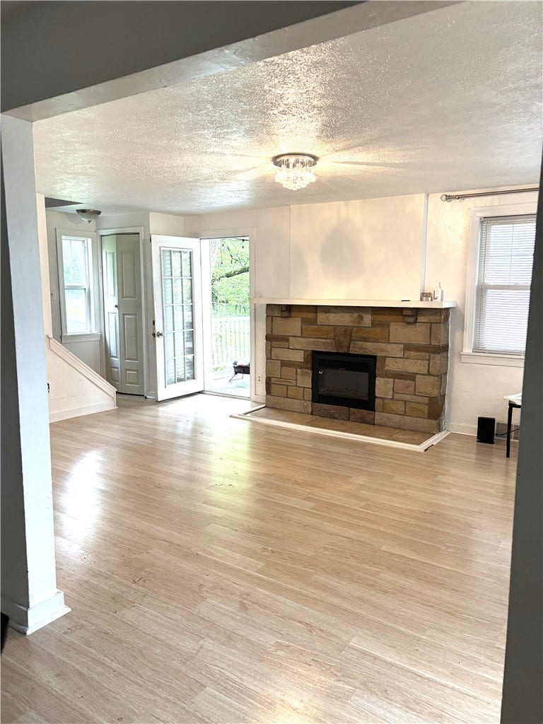 1008 Fidelity, Pittsburgh, PA 15236 main floor living room with cozy fireplace leading out to the covered patio