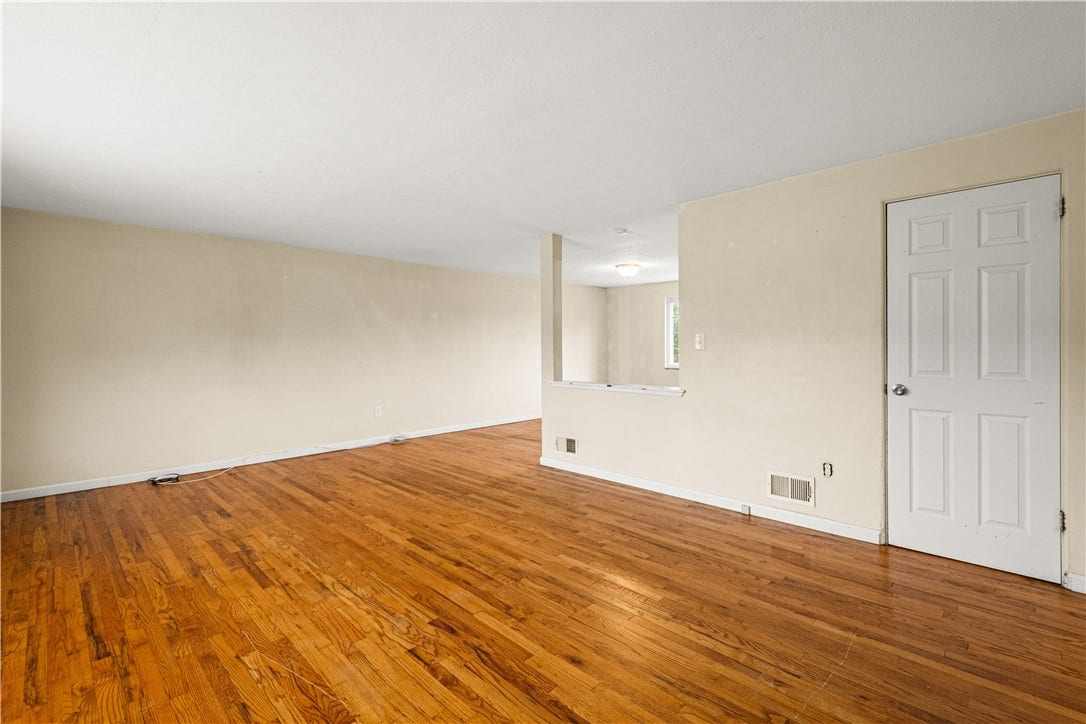 329 Macassar Dr, Pittsburgh, PA 15236 Living room with hard wood floors opens to dining room. Door is to closet.