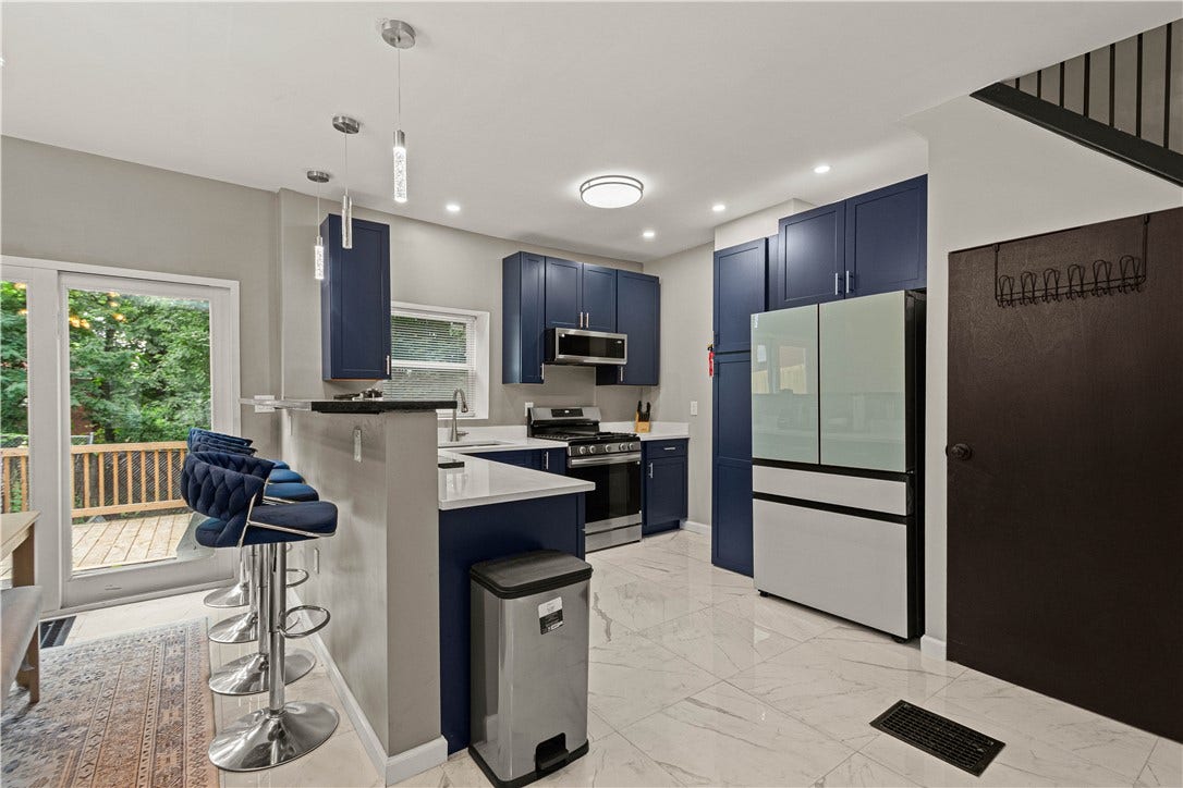 214 N Aiken Ave, Pittsburgh, PA 15206 Navy shaker cabinetry, quartz counters and breakfast bar