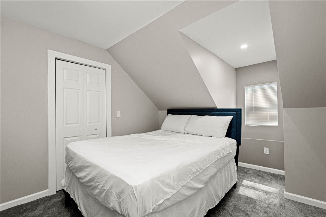 214 N Aiken Ave, Pittsburgh, PA 15206 Third-floor bedroom with electric fireplace and wall-mounted TV