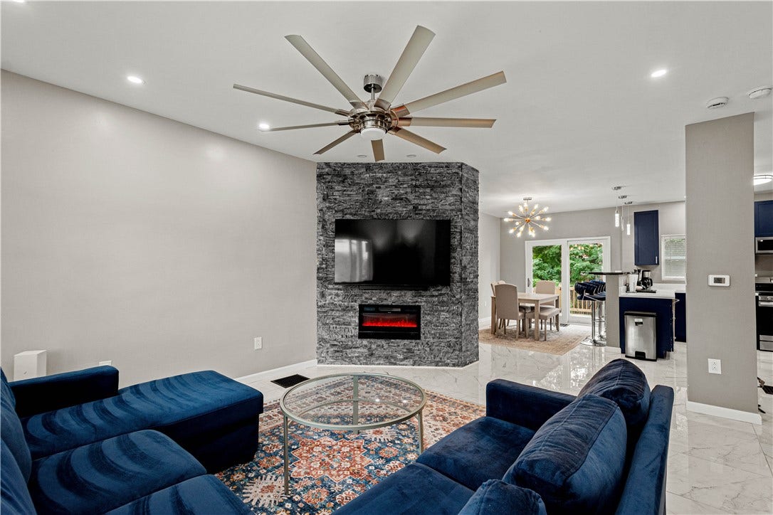 214 N Aiken Ave, Pittsburgh, PA 15206 Open main level with stacked-stone feature wall and electric fireplace