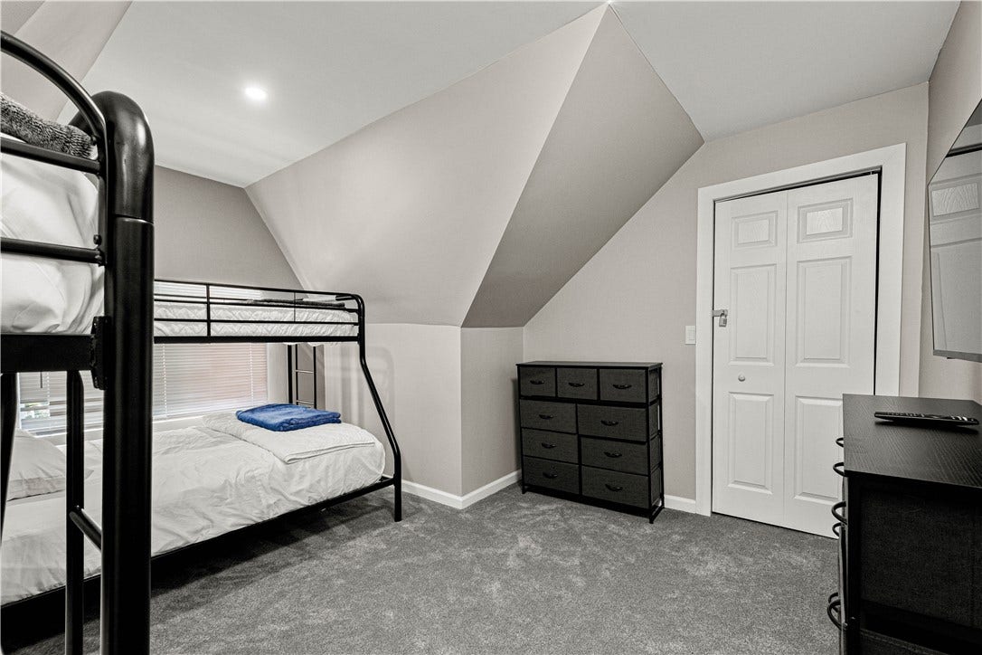 214 N Aiken Ave, Pittsburgh, PA 15206 Third-floor bedroom with electric fireplace and wall-mounted TV