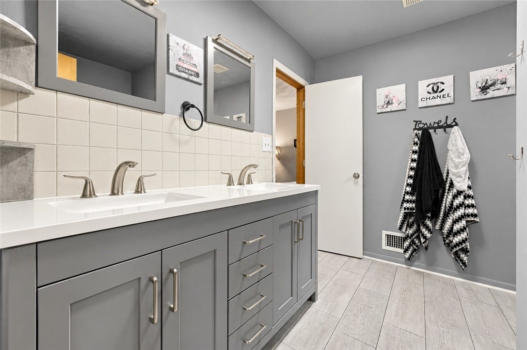 Convenience for everyone! This full bath offers direct access from the primary bedroom plus hallway access for the other bedrooms, along with a spacious double vanity.