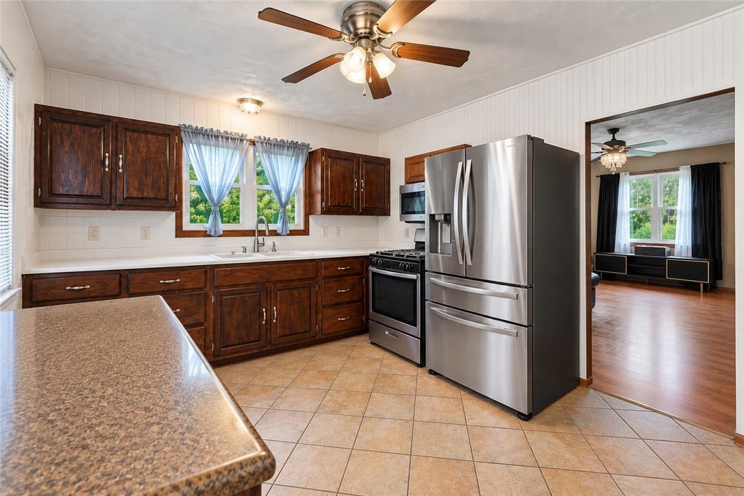 Bright and ready for your favorite recipes- this spacious kitchen offers plenty of counter space, rich wood cabinetry, and stainless-steel appliances!