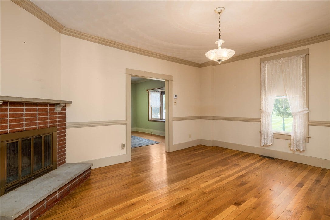 16'11" x 14'4" SPACIOUS DINING ROOM WITH BEAUTIFUL WOOD BURNING FIREPLACE AND GLEAMING HARDWOOD FLOORS.