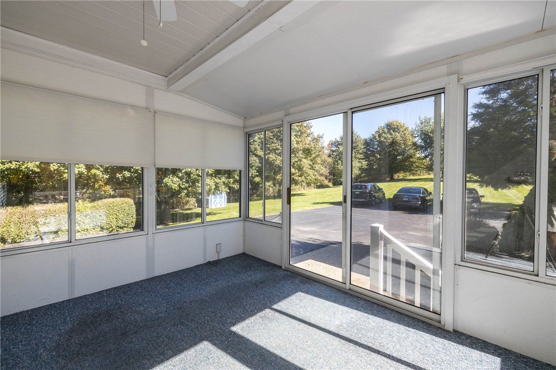 ANOTHER VIEW OF THE SCREENED IN THREE SEASON ROOM WITH A VIEW OF THE EXTRA PARKING AREA.