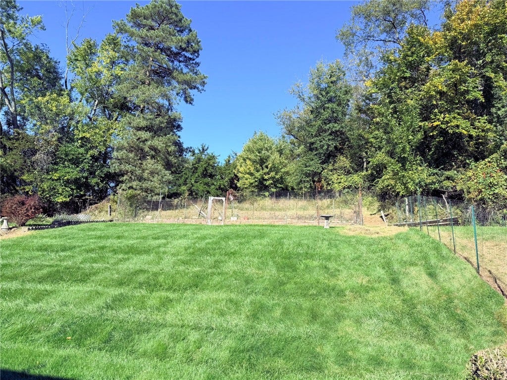The previous owners loved to garden and left this fenced area at the rear of the property.  This property backs to woods and meadows for your privacy.