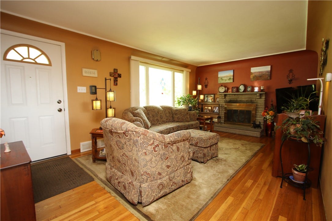 4239 Finleyville Elrama Road, Finleyville, PA 15332 Large 18x12 Living Room featuring Original Hardwood Floors, Gas Stone Fireplace highlighted by Brass Framed Glass Door Enclosure. Big Front Picture Window w/ Classic Marble Sills inviting in the Natural Light. Classic Plaster Walls complemented by Architectural Coved Ceilings